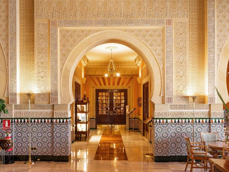 タイル装飾とアーチがあるAlhambra Palace Hotelのロビー